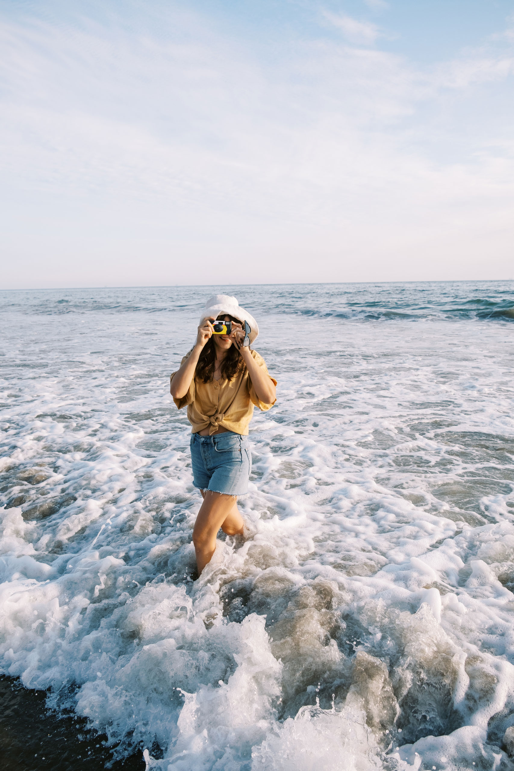 Woman with camera at water's edge