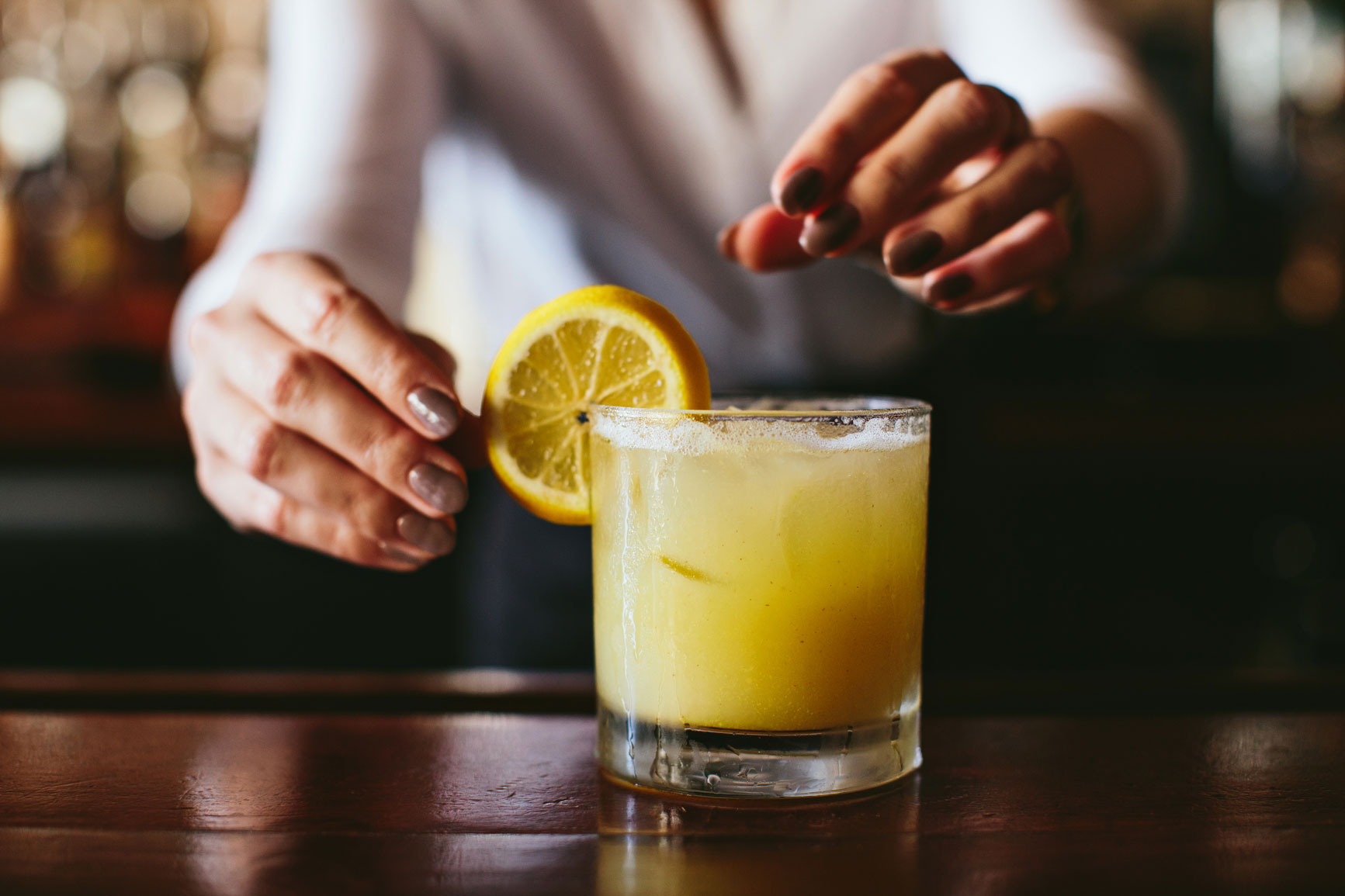 Cocktail with lemon twist over rim of glass