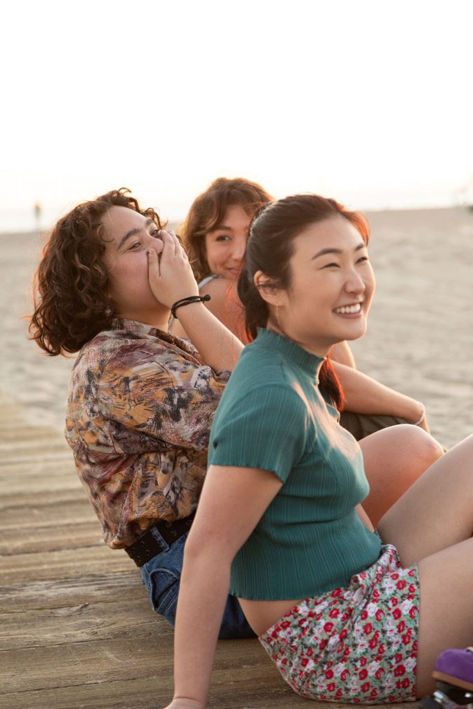 Three women sitting on a beach