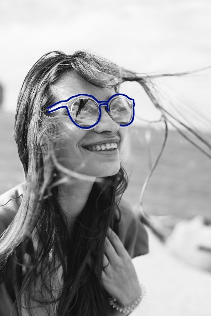 Woman with sunglasses outlined in blue at the beach